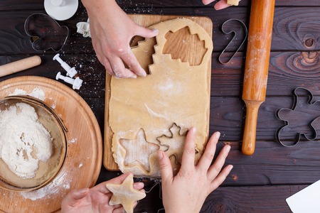 Gingerbread making. Friends cutting cookies of gingerbread doughの写真素材