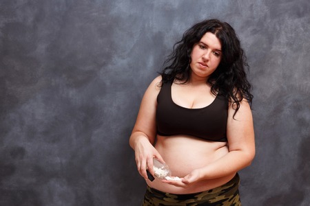Overweight fat woman taking slimming pills. Weight loosing, dietの写真素材