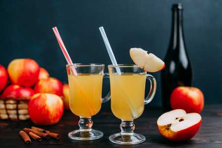 Two glasses of hot and spicy apple cider decorated with cocktailの写真素材