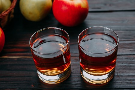 Sweet fresh apple juice and tasty apples on dark wooden table. Oの写真素材