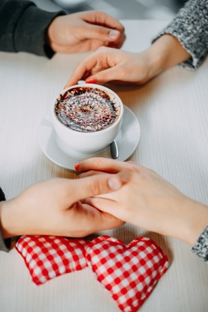 Romantic background, cup of coffee and hands of couple in love oの写真素材