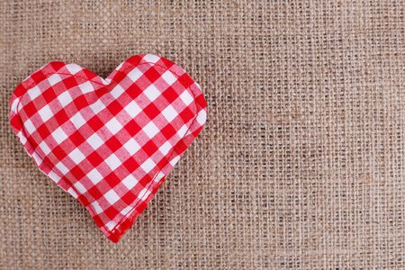 Valentines Day background. Handmade checkered fabric heart on saの写真素材