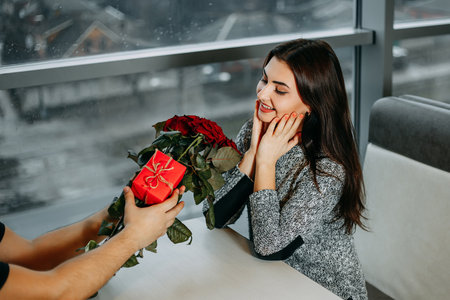 Young attractive happy woman got beautiful bouquet of red rosesの写真素材
