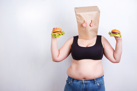 Obese fat  woman with a paper bag on head like a mask with eyesの写真素材