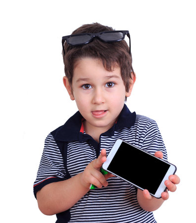Cute little boy demonstrating blank screen smartphone in hands,