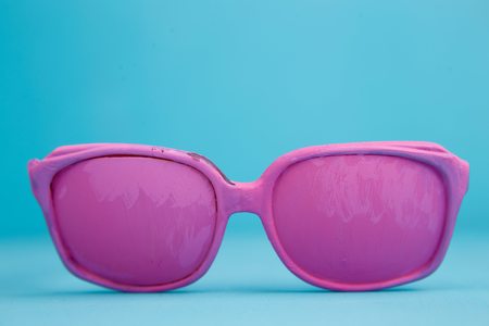 Pink bright pastel eyeglasses on blue background, holiday, sprinの写真素材