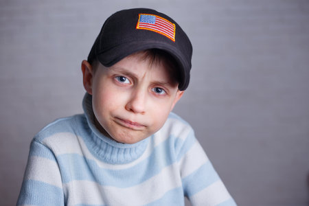 Close up portrait of cute boy in baseball cap with USA flag striの写真素材