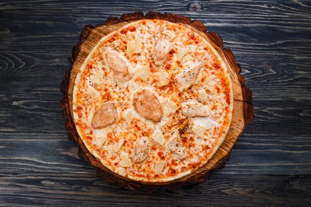 Traditional italian food. Fresh pizza with chicken and pineappleの写真素材