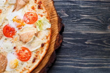 Delicious caesar pizza with cherry tomatoes, grilled chicken, leの写真素材