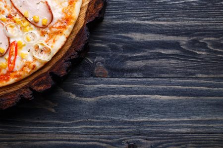 Delicious pizza with smoked chicken fillet, sweet corn and tomatの写真素材