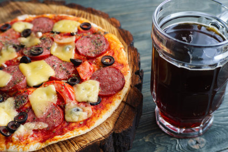 Pub or pizzeria concept. Delicious pizza and mug of dark beer, c