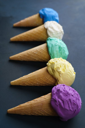 Various colored ice cream cones on black table