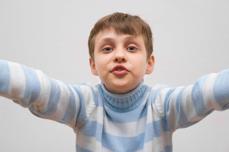 Portrait of cute little funny boy making selfie, close up