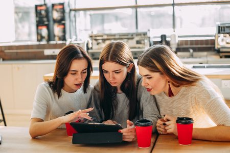 Students read and discuss content at tablet pcの写真素材