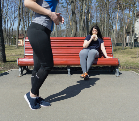 Overweight lazy woman eating junk food instead of training. Outdの写真素材