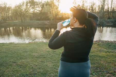 Overweight woman wiping sweat and drinking water
