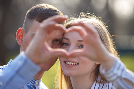 Couple looking through a heart made with  fingersの写真素材