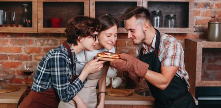 Three friends enjoy smell of freshly baked pizzaの写真素材
