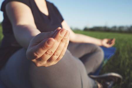 Overweight woman meditating at yoga mat outdoorsの写真素材