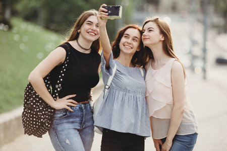Friends taking selfie outdoors using retro camera