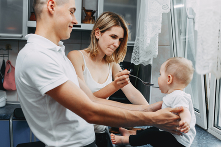 Mother feeding her baby daughter with spoonの写真素材