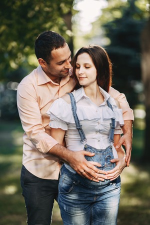 Pregnant couple walking in the park, huggingの写真素材