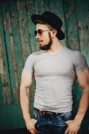 Brutal muscular bearded hipster man at grungy background