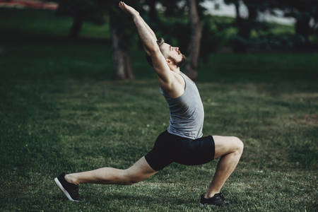 Man warming up outdoors, stretching core and legsの写真素材