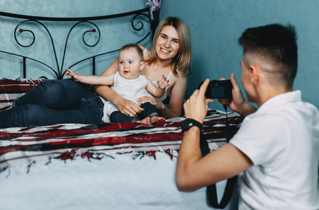 Father taking pictures of mother and daughterの写真素材