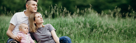 Family sitting at grass together dreamingの写真素材