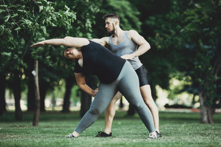 Personal trainer correct client doing exerciseの写真素材
