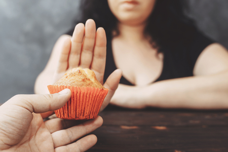 overweight woman refusing muffinの写真素材