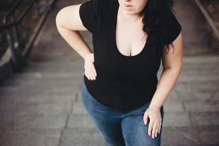 Overweight woman suffering from breathe shortness stepping on stの写真素材