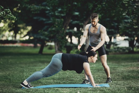 Personal trainer working with his client outdoorsの写真素材