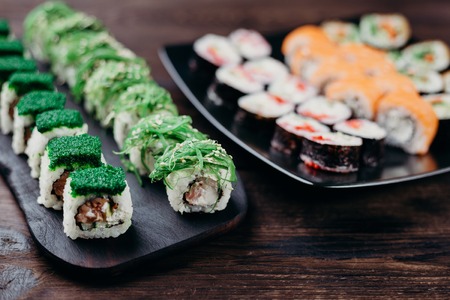 assortment of sushi rolls served on black plateの写真素材