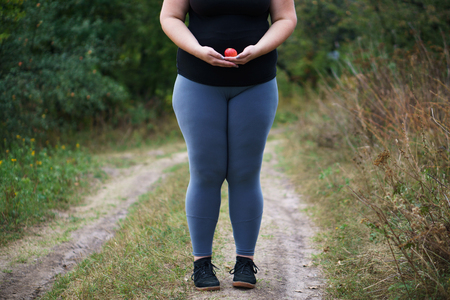 Overweight fat woman with little appleの写真素材
