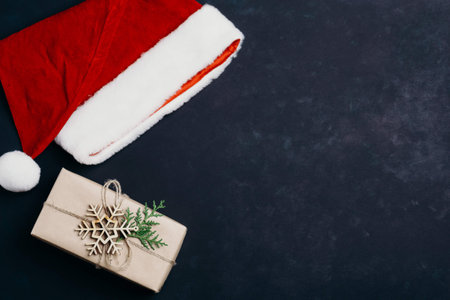 Santa Claus cap and gift box on dark background