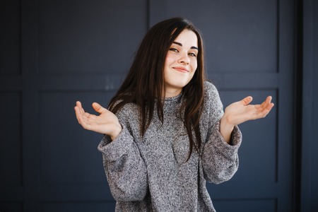 Shocked surprised smiling woman with spread handsの写真素材