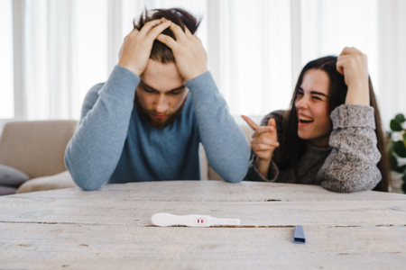 Frustrated man and happy woman with positive testの写真素材