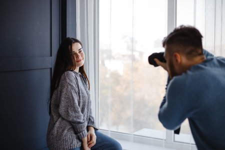 Photographer taking pictures of woman in studioの写真素材