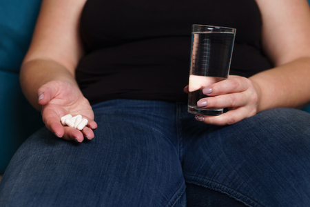 Desperate fat woman taking pills. weight lossの写真素材