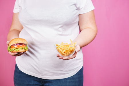 Weight loss, unhealthy food. woman with fast foodの写真素材