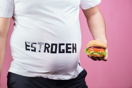 hormonal imbalance. overweight man with fast foodの写真素材