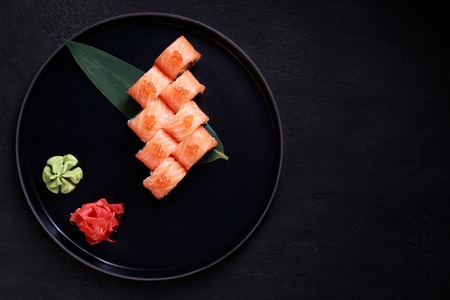 sushi rolls with salmon and caviar on black plateの写真素材