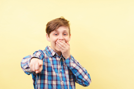 boy mocking and laughing pointing finger at viewerの写真素材