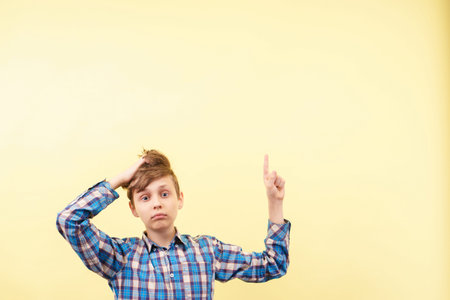 shocked boy points with finger at empty space