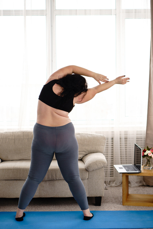 Overweight woman doing stretching exercisesの写真素材