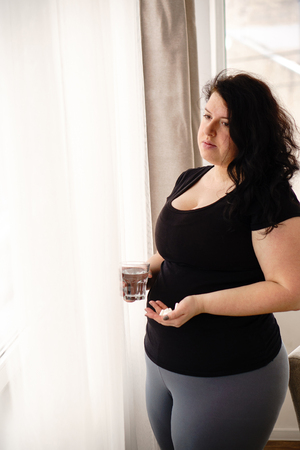 Desperate fat woman taking pills. weight lossの写真素材