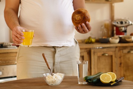 Overweight man choosing healthy or junk foodの写真素材