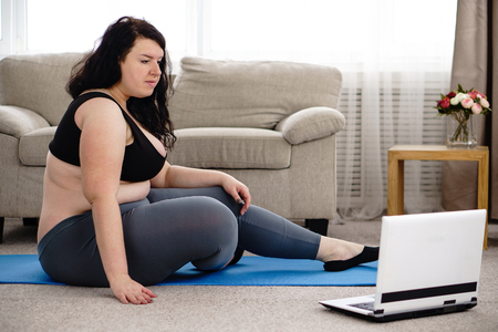 Overweight woman rest after yoga workout at homeの写真素材